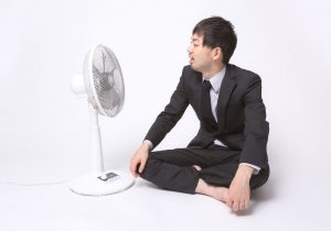 扇風機にあたるサラリーマン